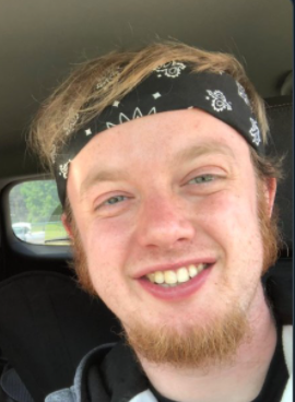 luke wenke cyberstalker blue bandana blond hair smiling sitting in vehicle
